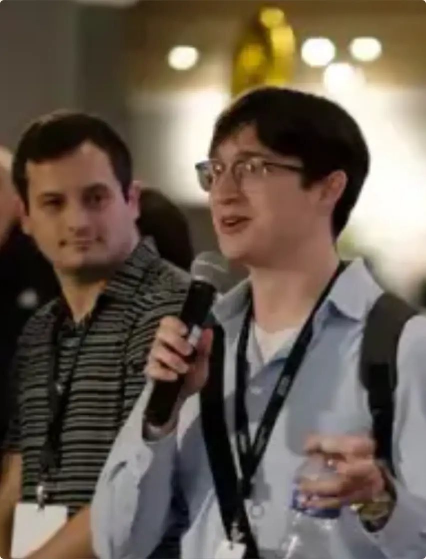 A founder pitching with a microphone at a past Roots event